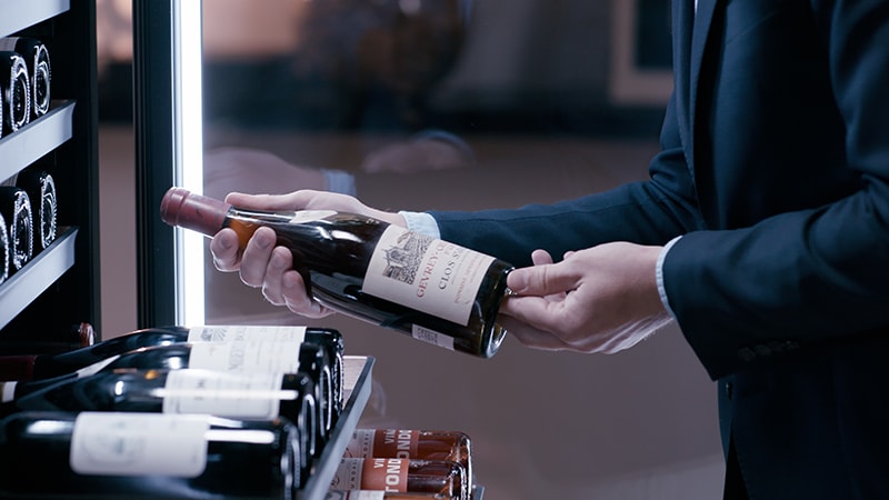MEDIUM SHOT SHELVES OUT HOLDING BOTTLE 4K.png